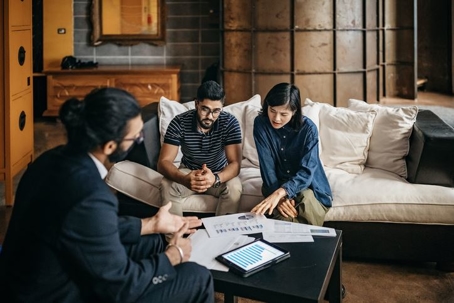 spouses reviewing property value documents with valuator