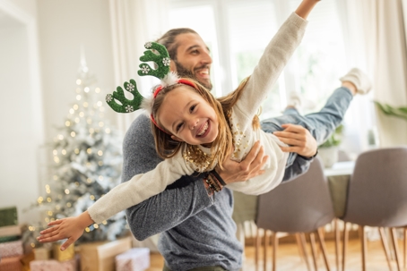 father and daughter playing inside during the holidays