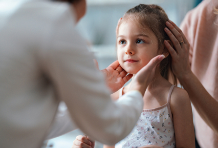 child with mother being checked by doctor