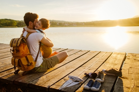 father and son hugging on a dock by a lake